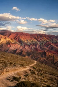 Montanhas coloridas de Hornocal, no norte da Argentina, com estrada sinuosa em meio à paisagem andina ao entardecer