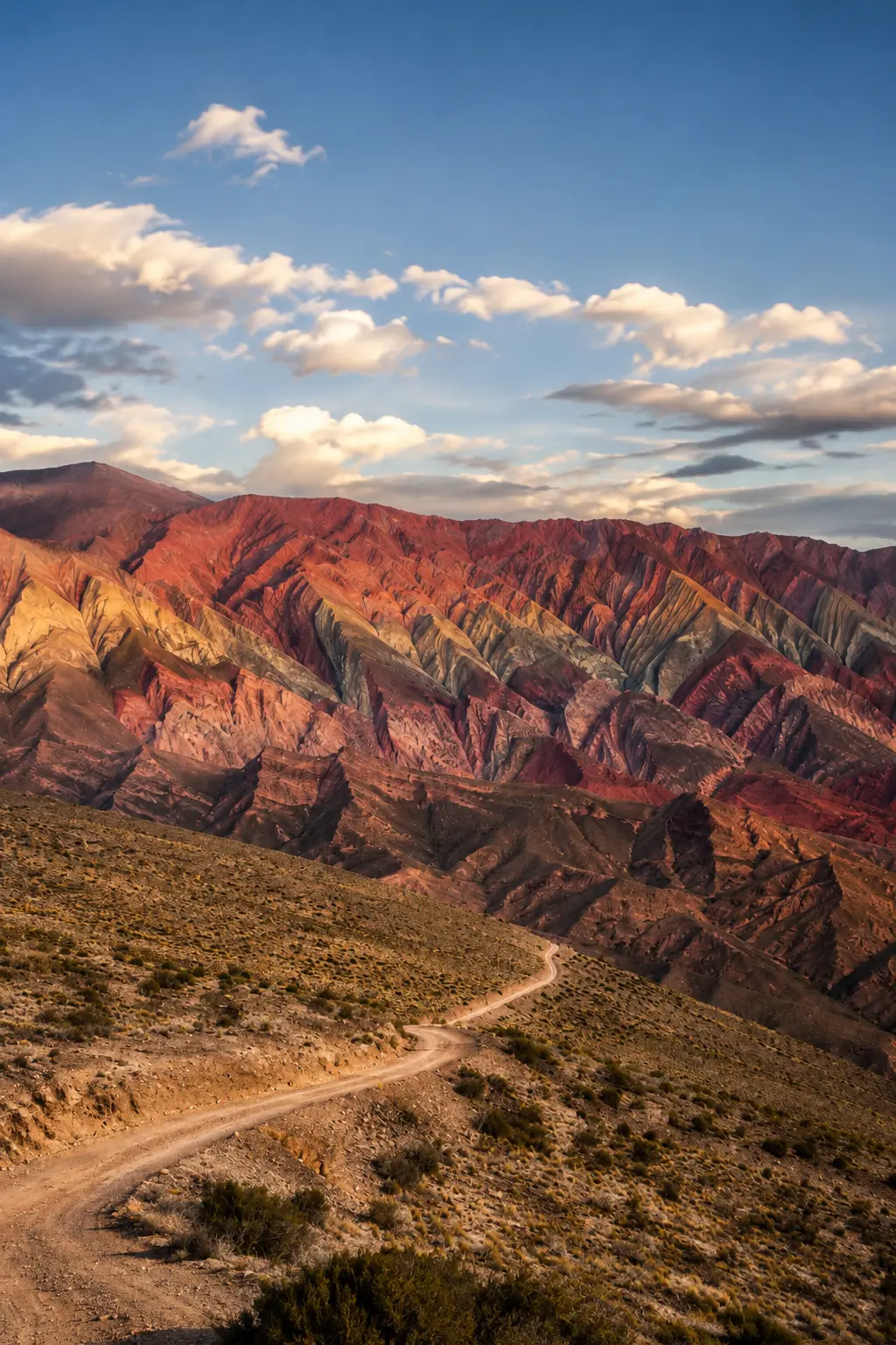 Montanhas coloridas de Hornocal, no norte da Argentina, com estrada sinuosa em meio à paisagem andina ao entardecer